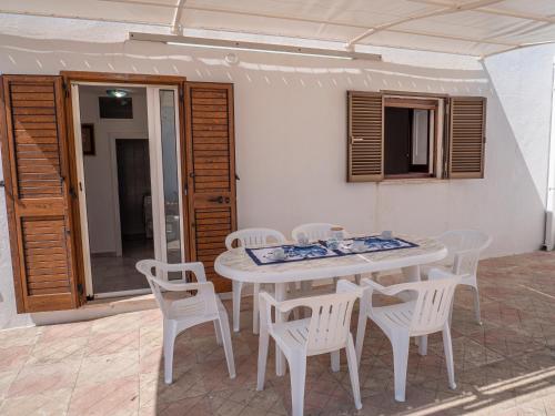 a white table and chairs on a patio at Villa Cordella 3 in Patù