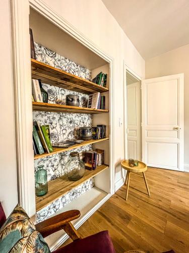 une chambre avec une étagère et des livres dans l'établissement Appartement Le A à Baccarat, à Baccarat