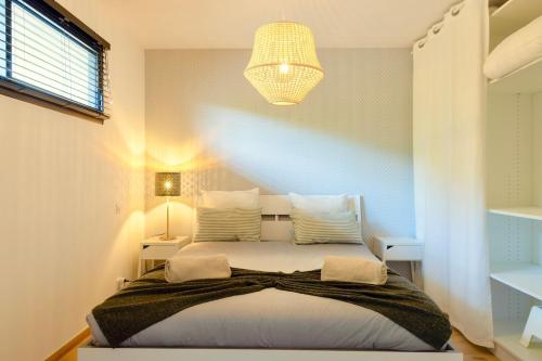 - une chambre avec un grand lit et un lustre dans l'établissement Villa Maquis, Vue mer, élégante maison au calme, 80m2, 4 personnes, à Pietrosella