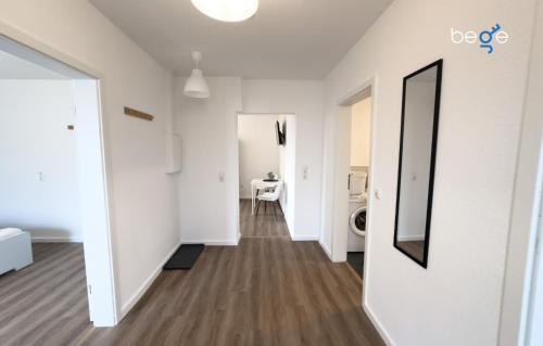a hallway of an apartment with white walls and a mirror at BEGE APARTMENTS ConnectPoint in Nettetal