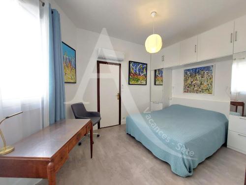 une chambre avec un lit, un bureau et une table dans l'établissement 3 chambres internet stationnement situation unique en 1ere ligne mer, à Sète