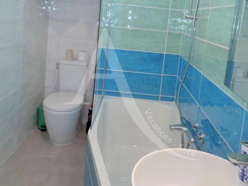 une salle de bain avec toilettes, baignoire et lavabo dans l'établissement 3 chambres internet stationnement situation unique en 1ere ligne mer, à Sète