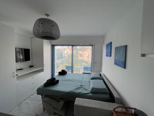 un salon avec un lit et une grande fenêtre dans l'établissement Mistral Seaside Studio - 200m de la Plage, à Cannes