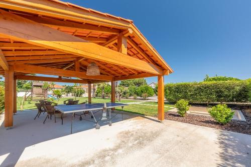 a wooden pavilion with a table and chairs at Magalhães Village by LovelyStay in Santo António da Charneca
