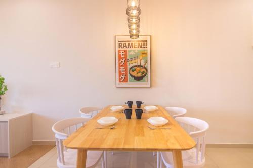 a dining room with a wooden table and chairs at Iconic Regency by Stellar ALV in Bayan Lepas
