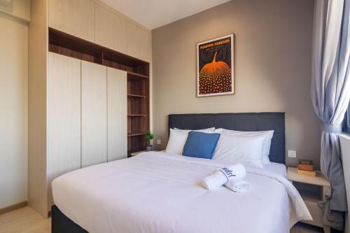 a bedroom with a large white bed with blue accents at Iconic Regency by Stellar ALV in Bayan Lepas