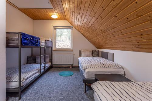 two bunk beds in a room with a wooden ceiling at Chata Bart in Krásný Les