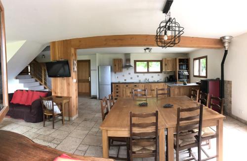 une cuisine et une salle à manger avec une table et des chaises dans l'établissement Gite La Grange sur les Bois, à Aiguebelette-le-Lac