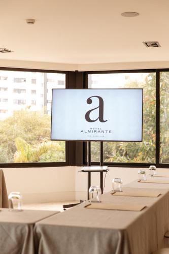 a projection screen in a room with tables at Hotel Almirante in Alicante