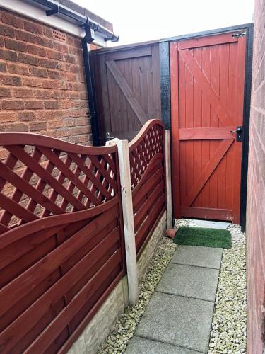 a pair of benches next to a red door at Lovely Double Room with En Suite and separate private entrance in Kingshurst