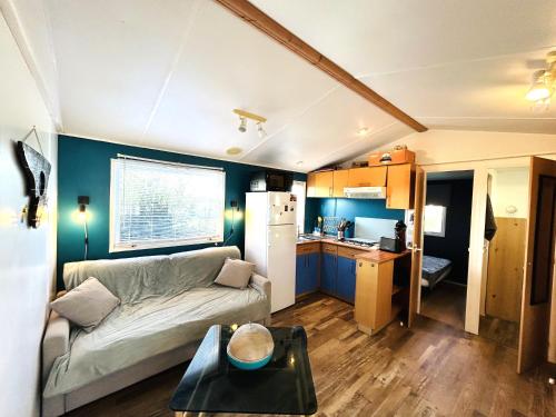 un salon avec un canapé et une cuisine dans l'établissement Charmant Mobile-home 6 personnes sur terrain privé à Guidel-Plages - ROZVEN, à Guidel