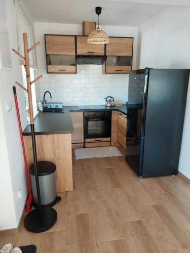 a kitchen with a black refrigerator and wooden cabinets at Plutowka in Zawoja
