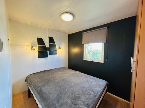 une chambre avec un lit et une fenêtre dans l'établissement Charmant Mobile-home 6 personnes sur terrain privé à Guidel-Plages - ROZVEN, à Guidel