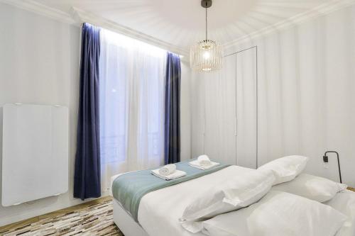 une chambre blanche avec un lit et une fenêtre dans l'établissement Stylish and New 2BR Flat in the Heart of Paris, à Paris