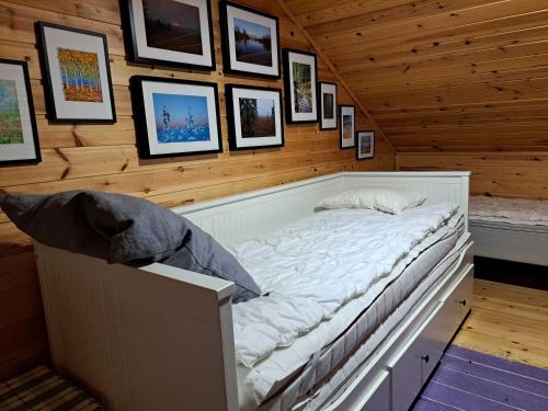 a bed in a room with pictures on the wall at Lomaloukas 1 in Syöte