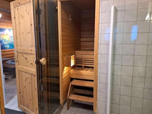 a sauna with a wooden cabinet in a bathroom at Lomaloukas 1 in Syöte