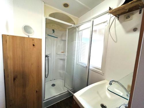 une salle de bain avec une douche, un lavabo et une baignoire dans l'établissement Charmant Mobile-home 6 personnes sur terrain privé à Guidel-Plages - ROZVEN, à Guidel