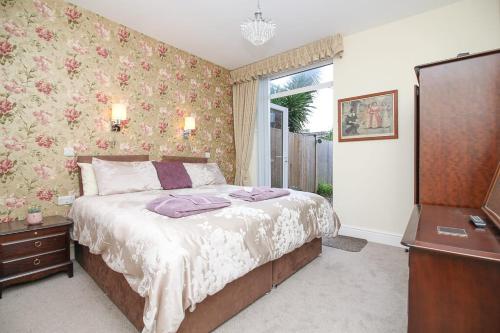 a bedroom with a bed with a dresser and a window at The Beach House Luxury Rooms in Weston-super-Mare