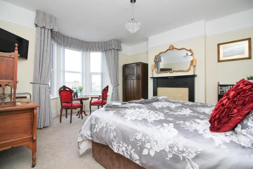 a bedroom with a bed and a table and chairs at The Beach House Luxury Rooms in Weston-super-Mare