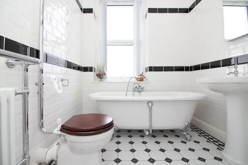 a bathroom with a tub and a toilet and a sink at The Beach House Luxury Rooms in Weston-super-Mare
