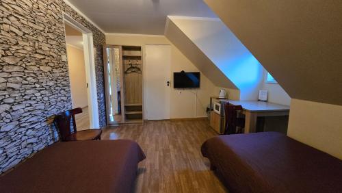 a room with two beds and a stone wall at Märjamaa Hostel in Märjamaa