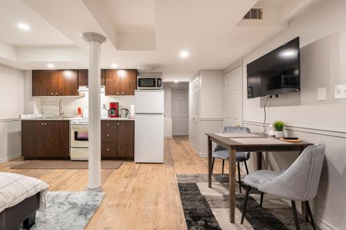 a kitchen and dining room with a table and a dining room at Modern, basement apartment, close to airport in Toronto