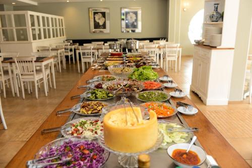 a long table with many plates of food on it at Astron Hotel Bauru by Nobile in Bauru