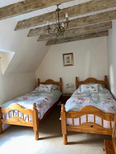 two twin beds in a bedroom with a chandelier at The Old Vicarage in Berwick-Upon-Tweed