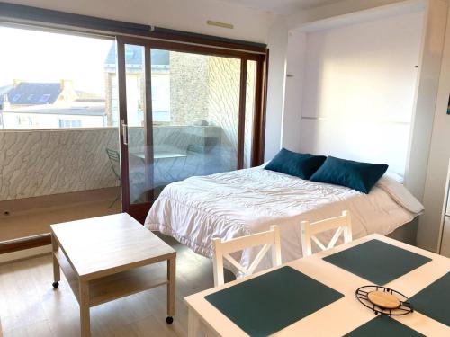 une chambre avec un lit et deux tables et une fenêtre dans l'établissement Appartement calme avec balcon, parking, près du port de Perros-Guirec - FR-1-368-412, à Perros-Guirec