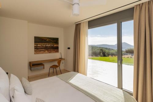 a bedroom with a bed and a desk and a window at Messinian Nest in Gialova