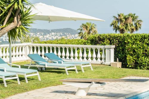 - un groupe de chaises et un parasol à côté de la piscine dans l'établissement Test test, à Nice