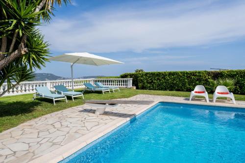 une piscine avec deux chaises et un parasol dans l'établissement Test test, à Nice