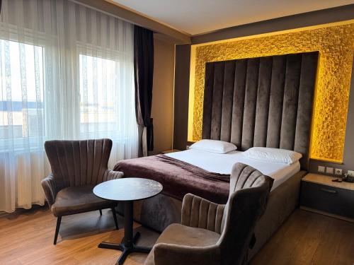 a hotel room with a bed and two chairs at Vera HOTEL-VILLA in Pristina