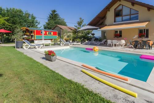 une maison avec une piscine avec des planches de surf dans la cour dans l'établissement Roulotte de bohême - Praline, à Truison