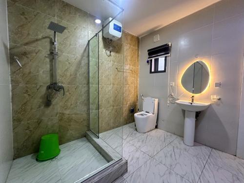 Un baño con ducha, lavabo e inodoro. en Modern comfort spot, en Lekki