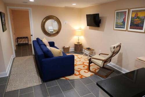 a living room with a blue couch and a chair at Rock Creek Park Residence in Washington, D.C.