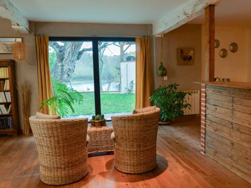 a living room with three chairs and a large window at Le COULOUMIER côté lac in Caignac