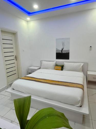 a bedroom with a large white bed with a blue light at Résidence Turpin in Toubab Dialaw