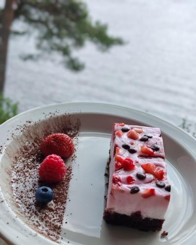 un pezzo di torta con bacche su un piatto bianco di Nature Dream Days a Muhos