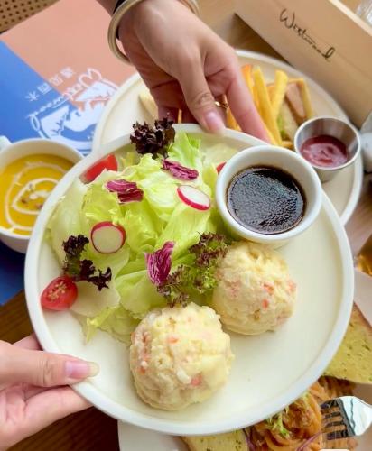 a plate of food with a salad and dipping sauce at Yangshuo 1Q84 Tree Hotel in Yangshuo