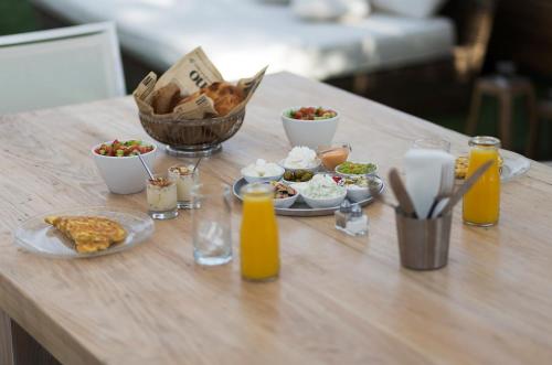 a table topped with plates of food and orange juice at Estate Spa Boutique Hotel - Adults Only in Rechovot