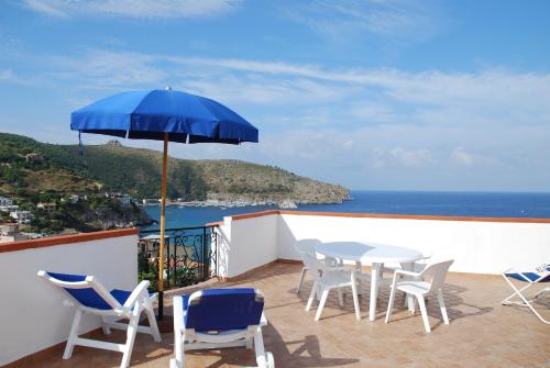 a patio with a table and chairs and an umbrella at Residence Riviera in Palinuro