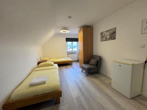 a room with two beds and a desk and a chair at Dasluki in Köngen