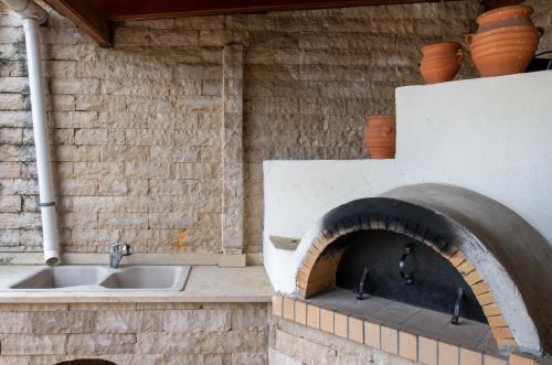 a kitchen with a sink and a brick oven at Barbati Angela's Garden Sea View in Barbati