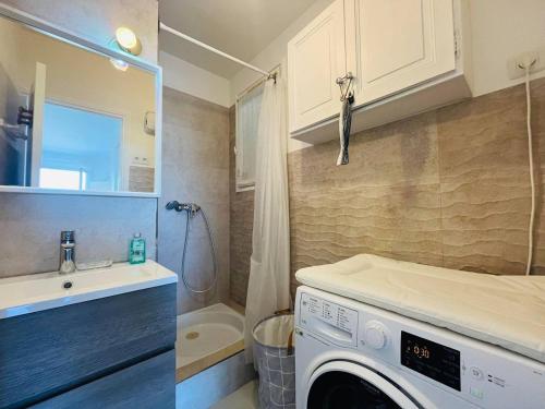 une cuisine avec lave-linge dans la salle de bains dans l'établissement Appartement Les Rochers CALVI, à Calvi