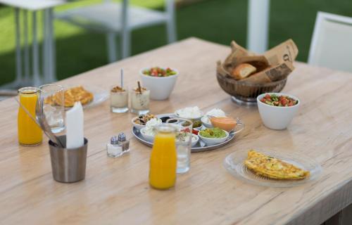 a table with plates of food and drinks on it at Estate Spa Boutique Hotel - Adults Only in Rechovot