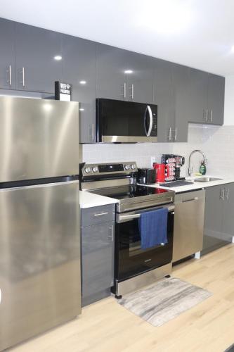 a kitchen with a stainless steel stove and refrigerator at DJoshuas place in Edmonton