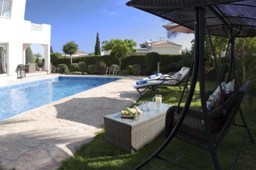 a patio with a table and an umbrella next to a pool at Villa Alysia by Ezoria Villas in Coral Bay