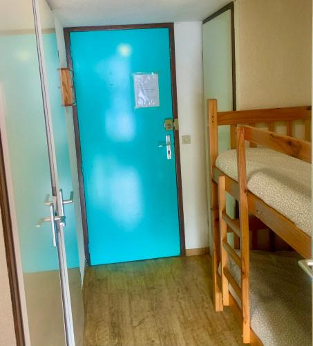 - une porte bleue dans un dortoir doté de lits superposés dans l'établissement Charmant appartement au pied des pistes, à Morillon