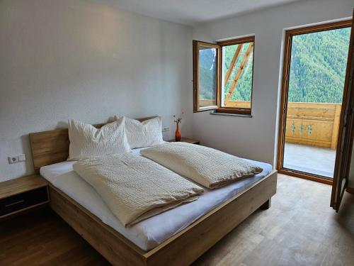 Postel nebo postele na pokoji v ubytování Alpenblick Lodge Tscholl